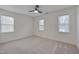 Spacious bedroom with neutral carpet, ceiling fan, and natural light from the three windows at 7024 Beaverwood Dr, Raleigh, NC 27616