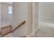 Well-lit hallway showcasing carpet flooring, stairway with wooden banister, and neutral wall paint, offering seamless transition at 7024 Beaverwood Dr, Raleigh, NC 27616