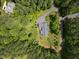 Drone's eye view of property, showcasing home's placement on landscaped lot, surrounded by mature trees at 741 Sinai Cir, Hillsborough, NC 27278