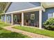Inviting covered front porch featuring rocking chairs, lush greenery, and a charming brick walkway, perfect for relaxation at 741 Sinai Cir, Hillsborough, NC 27278