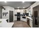 Modern kitchen featuring stainless steel appliances, farmhouse sink, and black backsplash at 741 Sinai Cir, Hillsborough, NC 27278