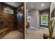 Modern main bathroom featuring a tiled shower, bench, and views to the backyard at 741 Sinai Cir, Hillsborough, NC 27278