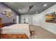 Large main bedroom with concrete floors, a king size bed, exercise equipment, and TV on the wall at 741 Sinai Cir, Hillsborough, NC 27278