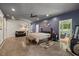 Large bedroom featuring a ceiling fan, concrete floors, and access to a sunroom at 741 Sinai Cir, Hillsborough, NC 27278