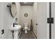 Tastefully designed powder room with pedestal sink, decorative mirror, and elegant vase at 741 Sinai Cir, Hillsborough, NC 27278