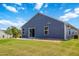 Back exterior of home featuring sliding glass doors, a small patio, and a wide lawn at 75 Springwood Ln, Franklinton, NC 27525