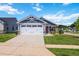 Exterior view of a house with a two-car garage, blue siding, and well-maintained lawn at 75 Springwood Ln, Franklinton, NC 27525