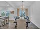 Bright dining area with wooden table set for six under modern chandelier, and bar seating at a counter at 81 Paperwhite Pl # 213, Clayton, NC 27527