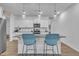 Bright, modern kitchen island with seating for two, white cabinets, granite counters, and stainless steel appliances at 81 Paperwhite Pl # 213, Clayton, NC 27527