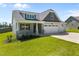 Inviting home featuring a welcoming front porch, attractive landscaping, and an attached three-car garage at 834 Mamie Upchurch Rd, Lillington, NC 27546