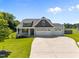 Charming home featuring a three-car garage, well-manicured lawn, and beautiful architectural details at 834 Mamie Upchurch Rd, Lillington, NC 27546