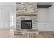 Living room with fireplace featuring stone surround and built in shelving at 834 Mamie Upchurch Rd, Lillington, NC 27546