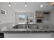 Modern kitchen featuring granite counters, stainless steel sink, and stone fireplace at 834 Mamie Upchurch Rd, Lillington, NC 27546