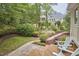 Backyard wooden deck and stone pathway surrounded by lush green landscaping at 8605 Stanton Pl, Raleigh, NC 27615