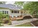 Backyard view of home featuring a wooden deck, chairs and stone pathway at 8605 Stanton Pl, Raleigh, NC 27615