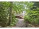 Wooded backyard featuring a deck, steps, and lattice creating an inviting outdoor space at 8605 Stanton Pl, Raleigh, NC 27615