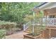 Backyard wooden deck and stairs with lush green landscaping at 8605 Stanton Pl, Raleigh, NC 27615
