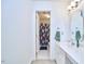 White bathroom features white cabinets and view to a second bath with floral curtain at 8605 Stanton Pl, Raleigh, NC 27615
