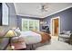 This is a well-lit bedroom with neutral colors, a ceiling fan, and an ensuite bath at 8605 Stanton Pl, Raleigh, NC 27615