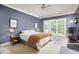 This is a well-lit bedroom with neutral colors, a ceiling fan, and a large window at 8605 Stanton Pl, Raleigh, NC 27615