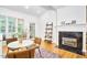 Bright breakfast nook features a fireplace, ladder shelf, and a round table next to a large window at 8605 Stanton Pl, Raleigh, NC 27615