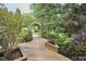 Inviting wooden deck and pergola amidst lush greenery, adding charm to the outdoor space at 8605 Stanton Pl, Raleigh, NC 27615