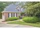 Beautiful brick home with lush landscaping, mature trees, and an attached garage at 8605 Stanton Pl, Raleigh, NC 27615