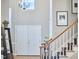 A foyer with hardwood floors, white staircase, and a large double front door at 8605 Stanton Pl, Raleigh, NC 27615