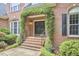 Close-up of an arched entrance with climbing vines leading to a brick home at 8605 Stanton Pl, Raleigh, NC 27615
