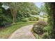 Landscaped front yard featuring a walkway, mature trees, and lush greenery leading to the home at 8605 Stanton Pl, Raleigh, NC 27615