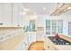 Well-lit kitchen featuring white cabinets, a center island, and large windows offering outdoor views at 8605 Stanton Pl, Raleigh, NC 27615