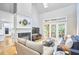 Bright living room with a fireplace, high ceilings, and French doors leading to a sunroom at 8605 Stanton Pl, Raleigh, NC 27615