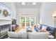 Bright living room with fireplace, skylights, and doors leading to sunroom at 8605 Stanton Pl, Raleigh, NC 27615