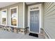 Close-up of a stylish front door with stone accents and ample natural light from the adjacent windows at 87 Browning Mill Dr, Wendell, NC 27591