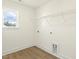 Bright laundry room featuring hardwood floors, window, and white walls at 87 Browning Mill Dr, Wendell, NC 27591