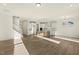 Open-concept living space features hardwood floors connecting the living area, staircase and modern kitchen at 87 Browning Mill Dr, Wendell, NC 27591