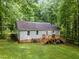 Aerial view of a house with a deck, set within a lush, tree-filled backyard at 8812 Valley Hill Ct, Apex, NC 27539