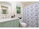 Well-lit bathroom features a stylish vanity, window, and shower with a patterned curtain at 8812 Valley Hill Ct, Apex, NC 27539