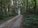 Long gravel driveway leading to a secluded home through a densely wooded lot at 8812 Valley Hill Ct, Apex, NC 27539