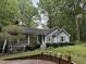 Charming home with landscaped front yard, covered porch, and light blue siding surrounded by lush trees at 8812 Valley Hill Ct, Apex, NC 27539