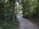 Charming home nestled among trees with a gravel driveway leading to the house at 8812 Valley Hill Ct, Apex, NC 27539