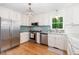 Bright kitchen features stainless appliances, white cabinets, blue backsplash, and hardwood floors at 8812 Valley Hill Ct, Apex, NC 27539