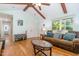 Open-concept living area with hardwood floors, exposed wooden beams, and a comfortable seating arrangement at 8812 Valley Hill Ct, Apex, NC 27539
