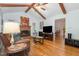 Bright living room with hardwood floors, a cozy fireplace, and vaulted ceilings with exposed wooden beams at 8812 Valley Hill Ct, Apex, NC 27539