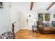 Comfortable living room featuring hardwood floors, exposed beams, a brown sofa, and ample natural light at 8812 Valley Hill Ct, Apex, NC 27539