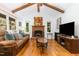 Spacious living room with a brick fireplace, hardwood floors, and exposed beams creating a cozy atmosphere at 8812 Valley Hill Ct, Apex, NC 27539
