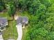 Aerial view of home and surrounding yard; lush green lawn, mature trees and attached garage at 9300 Glendora Ct, Garner, NC 27529