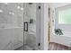 Bathroom featuring glass shower, white marble tile, and separate tub at 9300 Glendora Ct, Garner, NC 27529