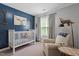 Cozy bedroom featuring a white crib, comfortable chair, and natural light from the window at 9300 Glendora Ct, Garner, NC 27529