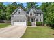 Beautifully landscaped front yard, gray siding, and a welcoming blue front door enhance curb appeal at 9300 Glendora Ct, Garner, NC 27529
